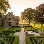 Luxe Nederlandse landhuis met professioneel ontworpen tuin, geometrische hagen en natuurstenen paden in gouden uurtje