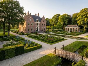 Elegant Nederlands landhuis met klassieke architectuur omringd door uitgebreide formele tuinen en gemanicuurde gazons