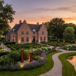 Elegant Nederlands landhuis met klassieke architectuur omgeven door uitgestrekte formele tuinen met heggen en paden