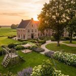 Nederlands landgoed met klassiek landhuis en kindvriendelijke tuin met speeltoestellen tussen bloembedden en gazons