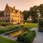 Nederlandse landhuis met klassieke bakstenen architectuur en moderne tuinontwerp met geometrische plantvakken en stenen paden.