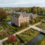 Luchtfoto van Nederlands landgoed met villa, geometrische tuinen, tulpenbedden en herfstbomen in traditionele setting