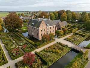 Luchtfoto van Nederlands landgoed met villa, geometrische tuinen, tulpenbedden en herfstbomen in traditionele setting