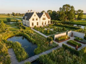 Nederlands landhuis met formele en natuurlijke tuinen in gouden avondlicht, diverse landschapsarchitectuur