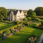 Nederlands landgoed met klassieke villa en uitgestrekte tuinen met geometrische hagen en gemaaide gazons