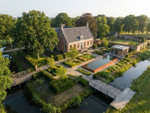 Luchtfoto van Nederlands landgoed met traditionele architectuur en moderne tuinarchitectuur in ochtendlicht