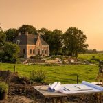 Nederlandse landgoed met klassiek landhuis en uitgebreide tuinontwerp in ontwikkeling, met plannen en gereedschap zichtbaar